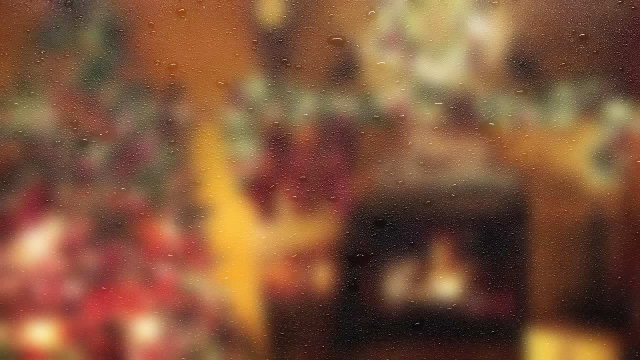 Rain on window with blurred Christmas lights and fire in background. Relaxing holiday atmosphere. Seamless loop