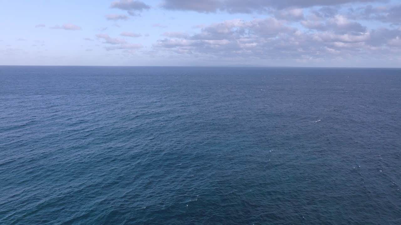 Vista aerea dell'Oceano Pacifico con movimento all'indietro e inclinazione verso il basso su bellissime onde blu turchese al largo della costa di Oahu, Hawaii