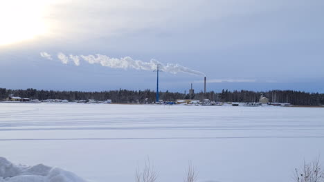 columns of smoke from smokestacks in snowy winter landscape