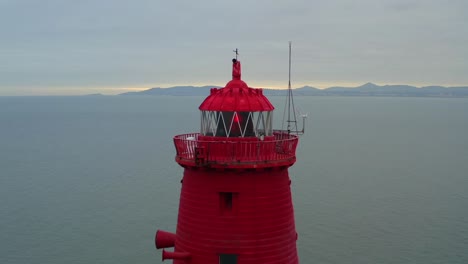 Faro-Octogonal-Rojo-De-Poolbeg-Al-Atardecer,-Plataforma-Rodante-Aérea-Inversa