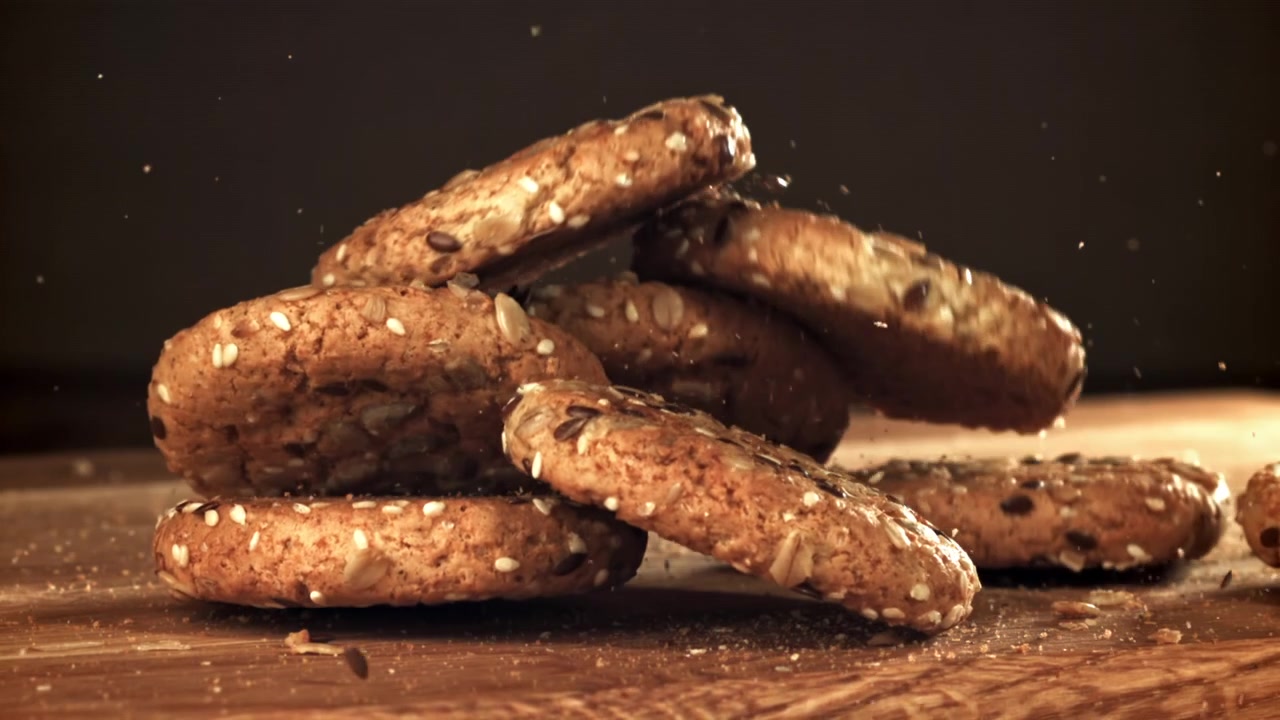 Delicious Seeded Cookies Falling in Slow Motion onto a Wooden Surface