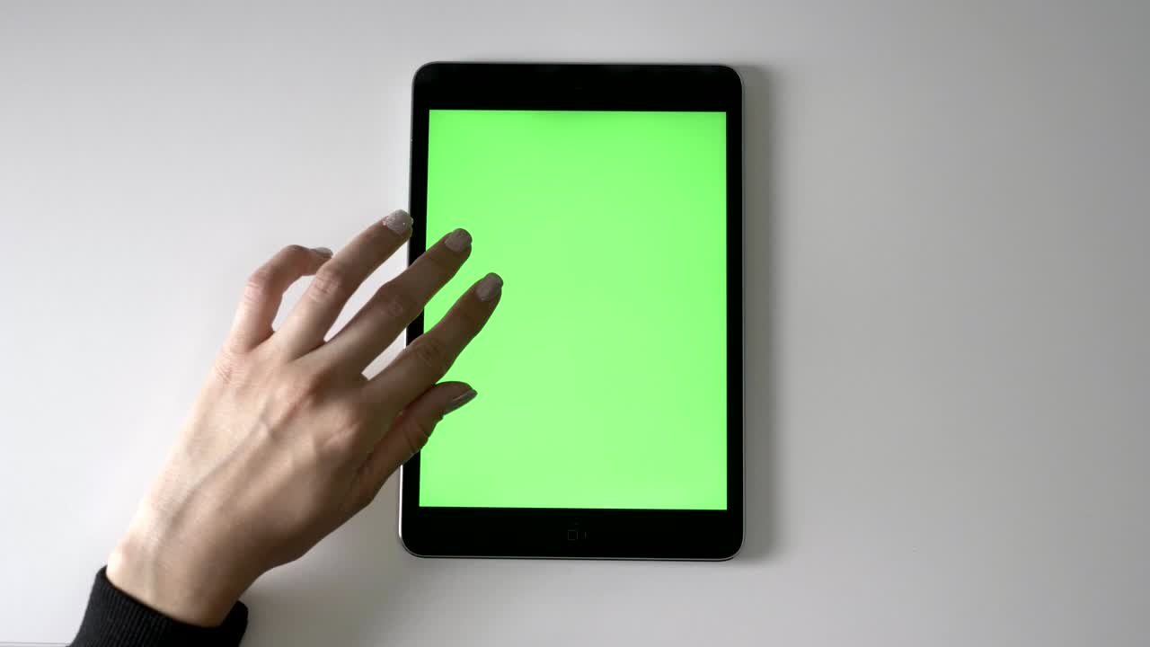 Female hand scrolling on tablet. Green screen, chromakey concept, Top shot 60 fps