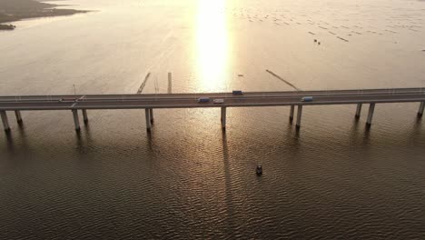 traffic on hong kong-shenzhen bay bridge at sunset, with fish and oyster cultivation pools, aerial view