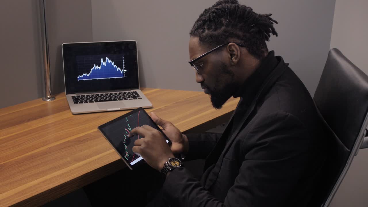 Black Businessman using laptop for analyzing data stock market, forex trading graph, stock exchange trading online, financial investment concept. close up