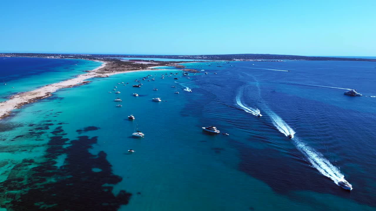 Ibiza Formentera coastline with numerous yachts and boats navigating crystal clear turquoise waters. Majestic aerial view flight drone top down Above view