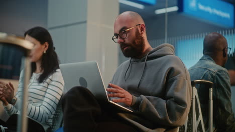 airport waiting area with passengers working on laptops
