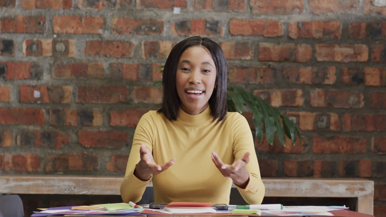 Happy african american casual businesswoman having video call, talking and gesturing, slow motion