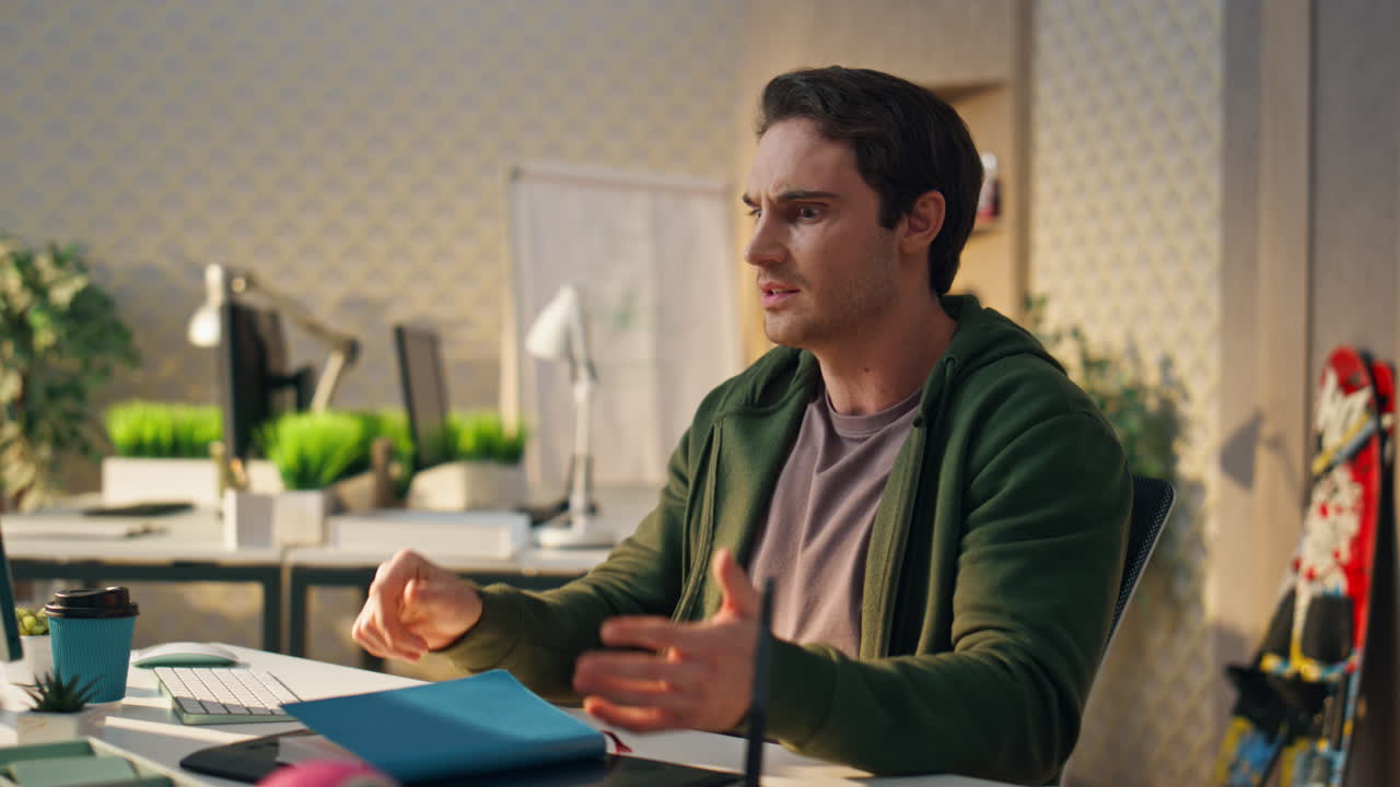 un principiante confundido leyendo un cuaderno en el escritorio del monitor. un hombre nervioso golpeando la mesa