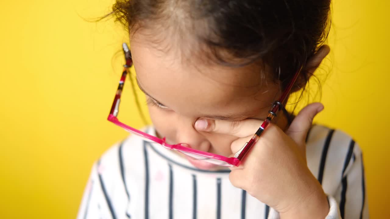 joven con gafas, tocando su ojo