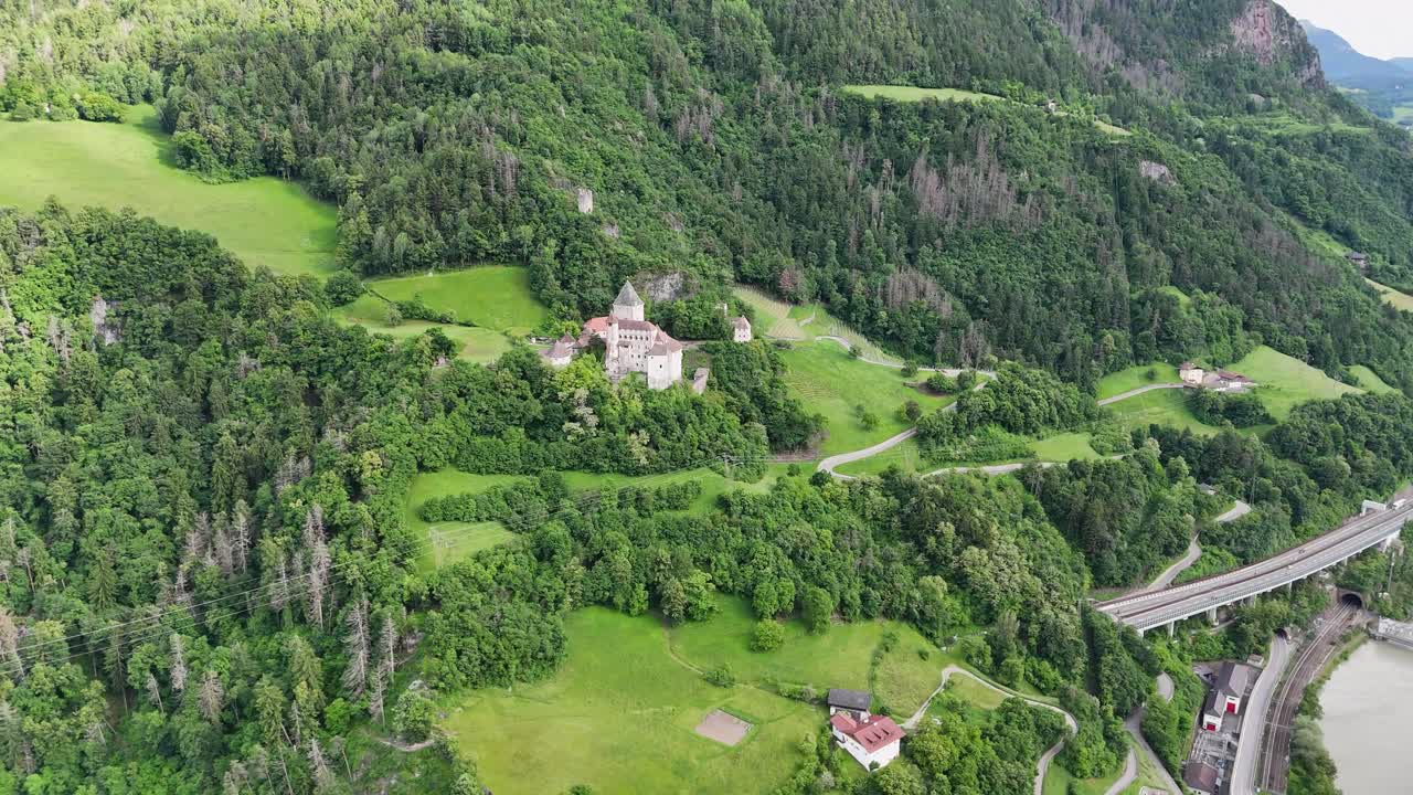Trostburg Castle and mountain landscape captured in a circular drone motion during summer in Italy