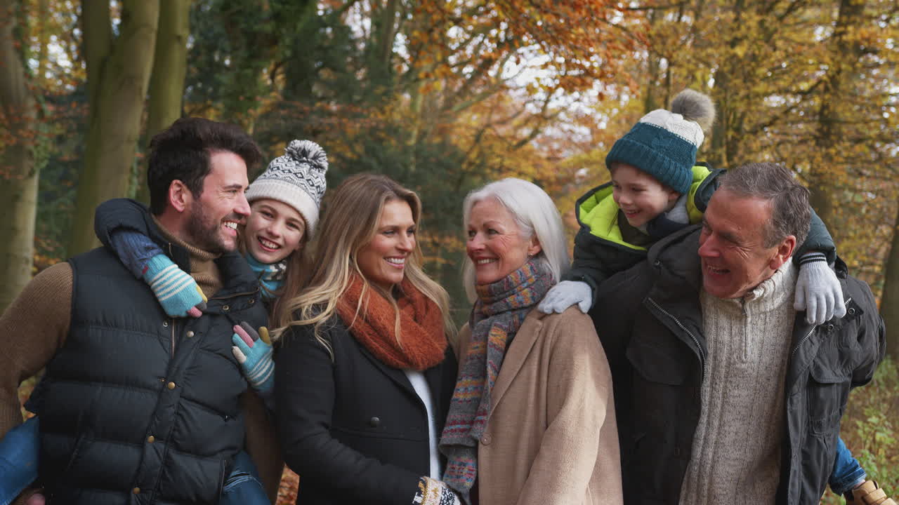 다세대 가족이 함께 가을 시골을 가로질러 걸어가는 초상화