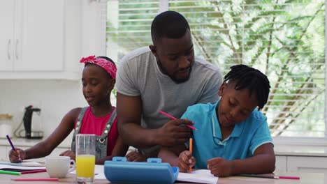 African-american-father-and-helping-his-son-with-homework-at-home