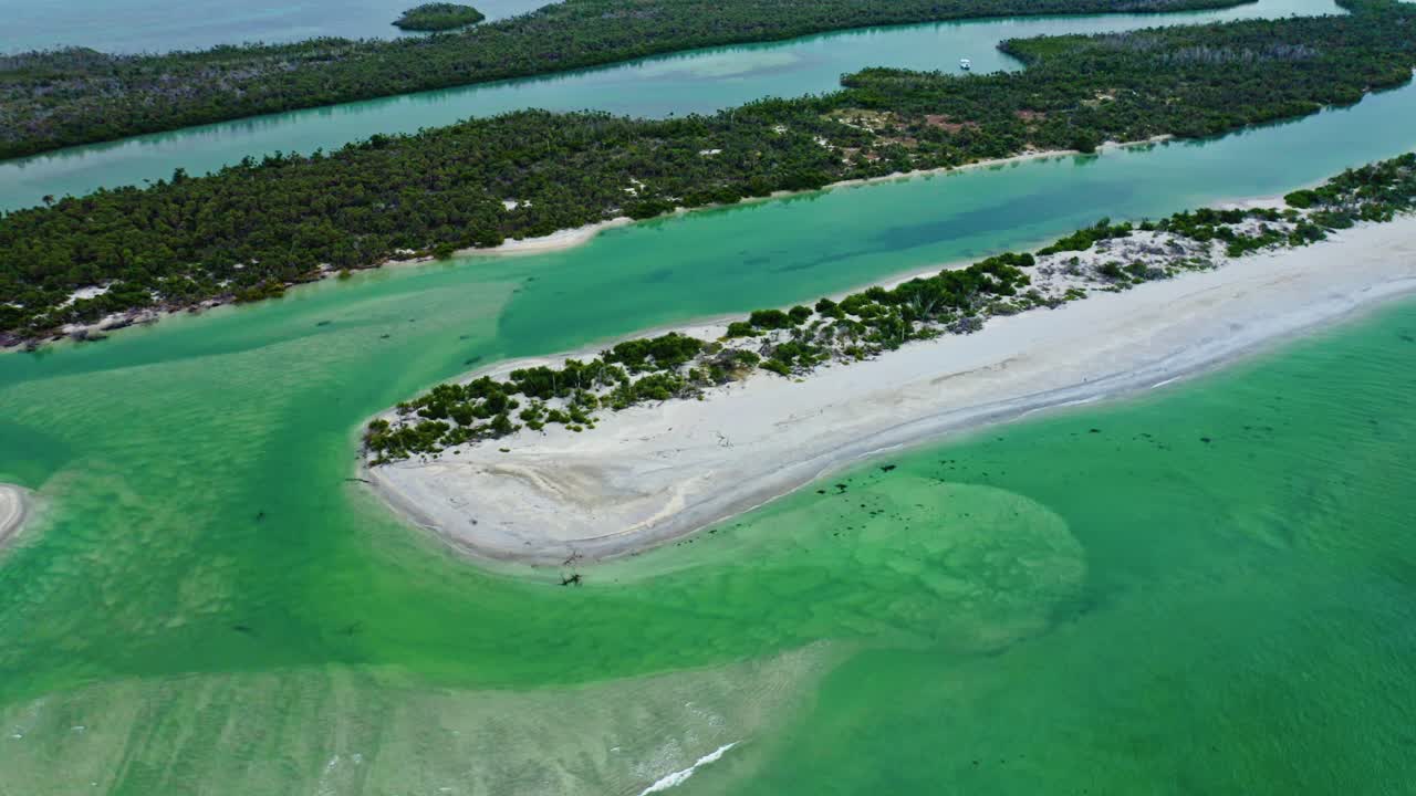 Curved sandbars and shifting turquoise shallows shape the tidal flow at Stump Pass, bordered by mangrove islands and narrow channels leading inland along Manasota Key on Florida’s Gulf Coast