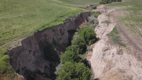 agriculture crop fields abut both sides of deep man-made erosion gully