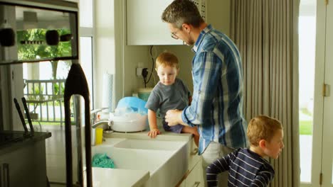 father and siblings cleaning kitchen sink 4k