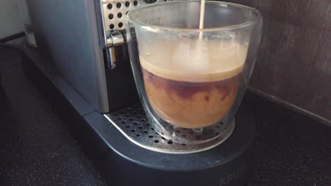 pouring milk intoa glass with coffee