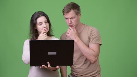 young couple using laptop and thinking together