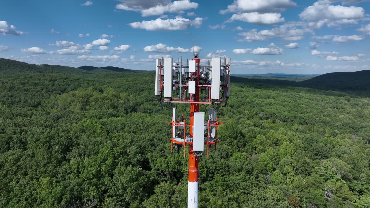 Cell transmission tower in forest landscape of USA. Aerial wide shot. Scenic sunny day in suburb of America. Supply neighborhood with television signal