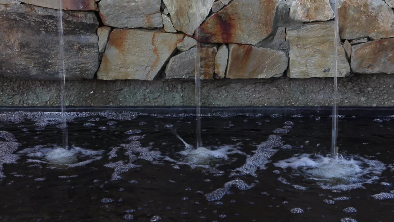 바위가 많은 도시 분수에는 세 개의 동일한 물 분출구가 있습니다.