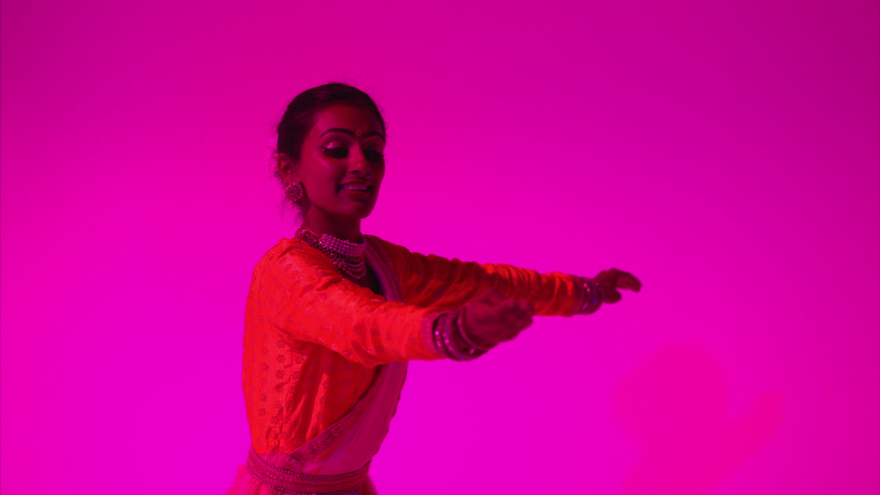 Studio Shot Of Female Kathak Dancer Performing Dance Wearing Traditional Indian Dress Against Purple Background 2