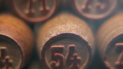 cinematic macro smooth shot of bingo wooden barrels in a row, woody figures, old numbers vintage board game, lucky number 54, slow motion, 4k commercial gimbal movement, dreamy lighting, tilt up