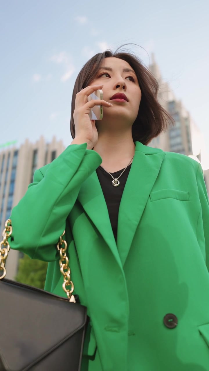 Giovane imprenditrice asiatica che parla al telefono in città