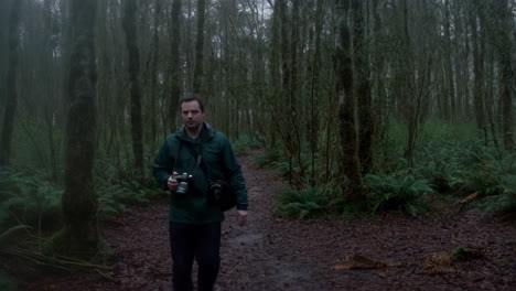 photographer walking through overcast forest
