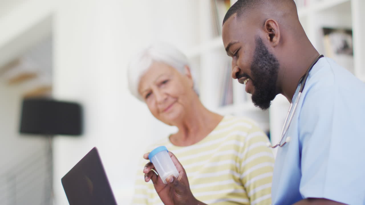 Video of hapopy african american male doctor giving medicines to caucasian senior woman
