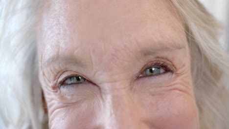 Portrait-of-happy-eyes-of-senior-caucasian-female-doctor-in-hospital-room,-slow-motion