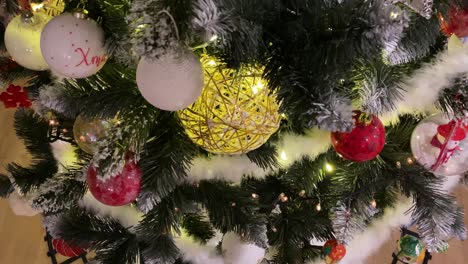 panning 4k footage of camera moving along beautiful decorated christmas tree with colourful baubles and lights