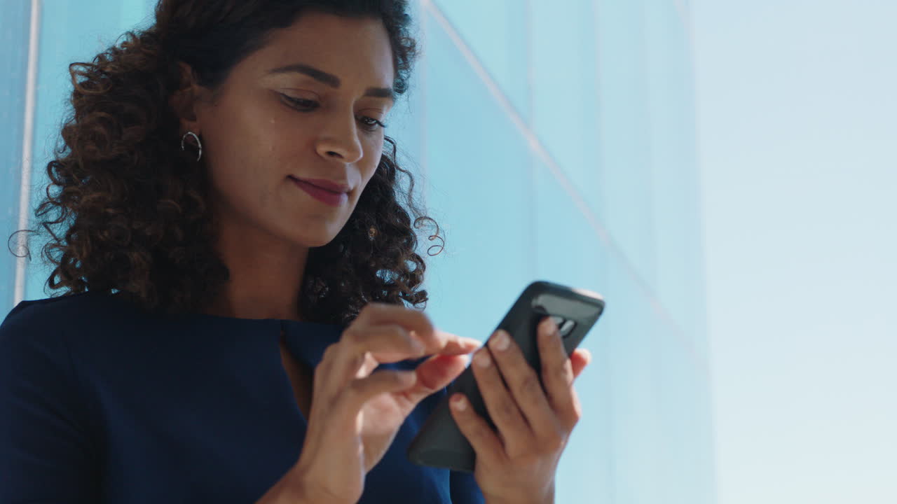 mujer de negocios usando un teléfono inteligente enviando mensajes de texto mujer ejecutiva comprobando correos electrónicos navegando mensajes en el teléfono móvil en la oficina