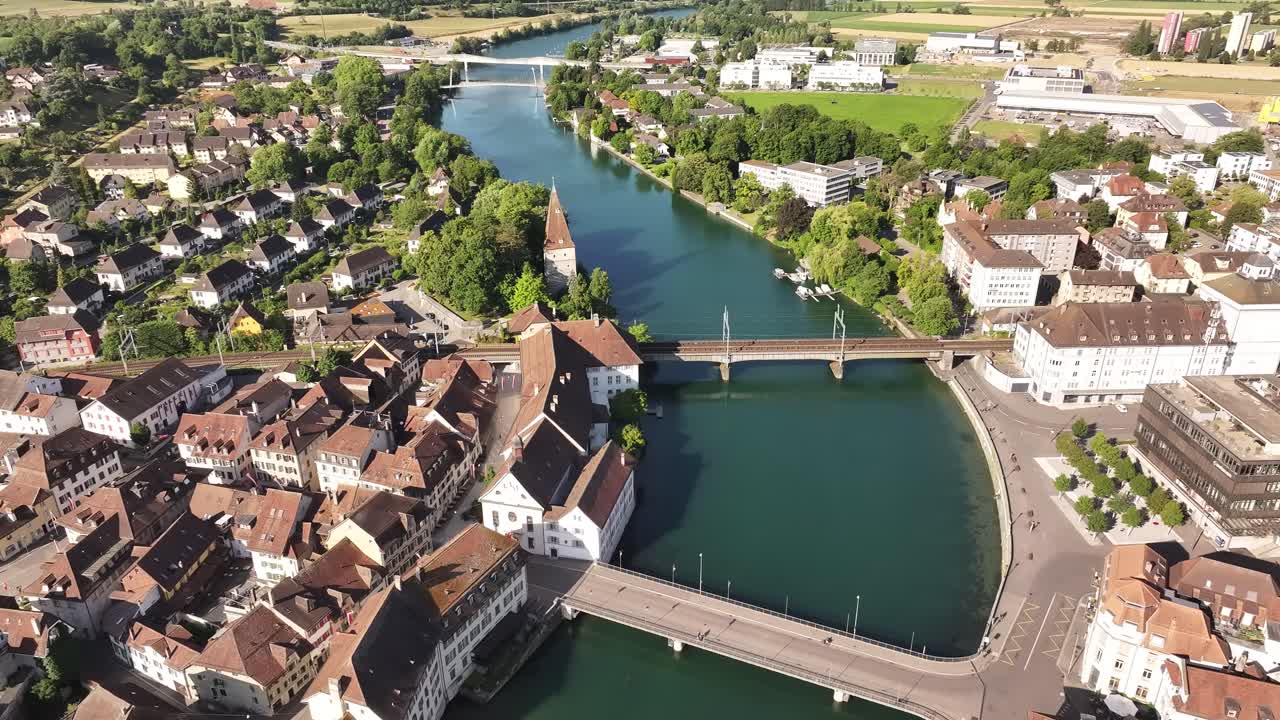 Aerial view of Aarau, Switzerland, with the Aare River winding through the historic city center, red rooftops, and scenic summer landscapes