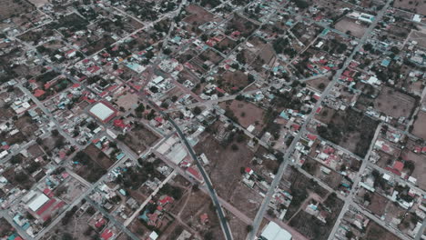 drone footage of nopaltepec, mexico, capturing city scenes with cars, houses, buildings, streets, and trees in a rural setting