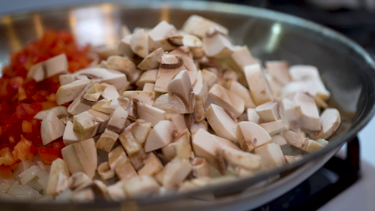 달궈진 프라이팬에 맛있고 다채로운 김이 나는 뜨거운 버섯, 양파, 붉은 고추 - 슬로우 모션