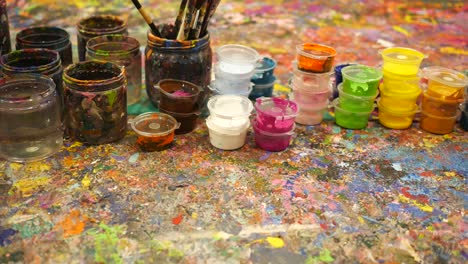 colorful paint supplies on a messy art table