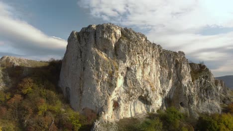 luftschwenk hochwinkelaufnahme eines großen hohen felsens am rande eines berges