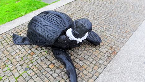 Tortuga-Hecha-De-Neumáticos-De-Coche-Con-Plástico-Alrededor-Del-Cuello,-Conciencia-Medioambiental