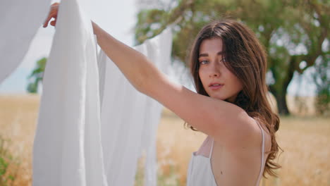 young housewife hanging laundry sun beams rural nature closeup. portrait woman