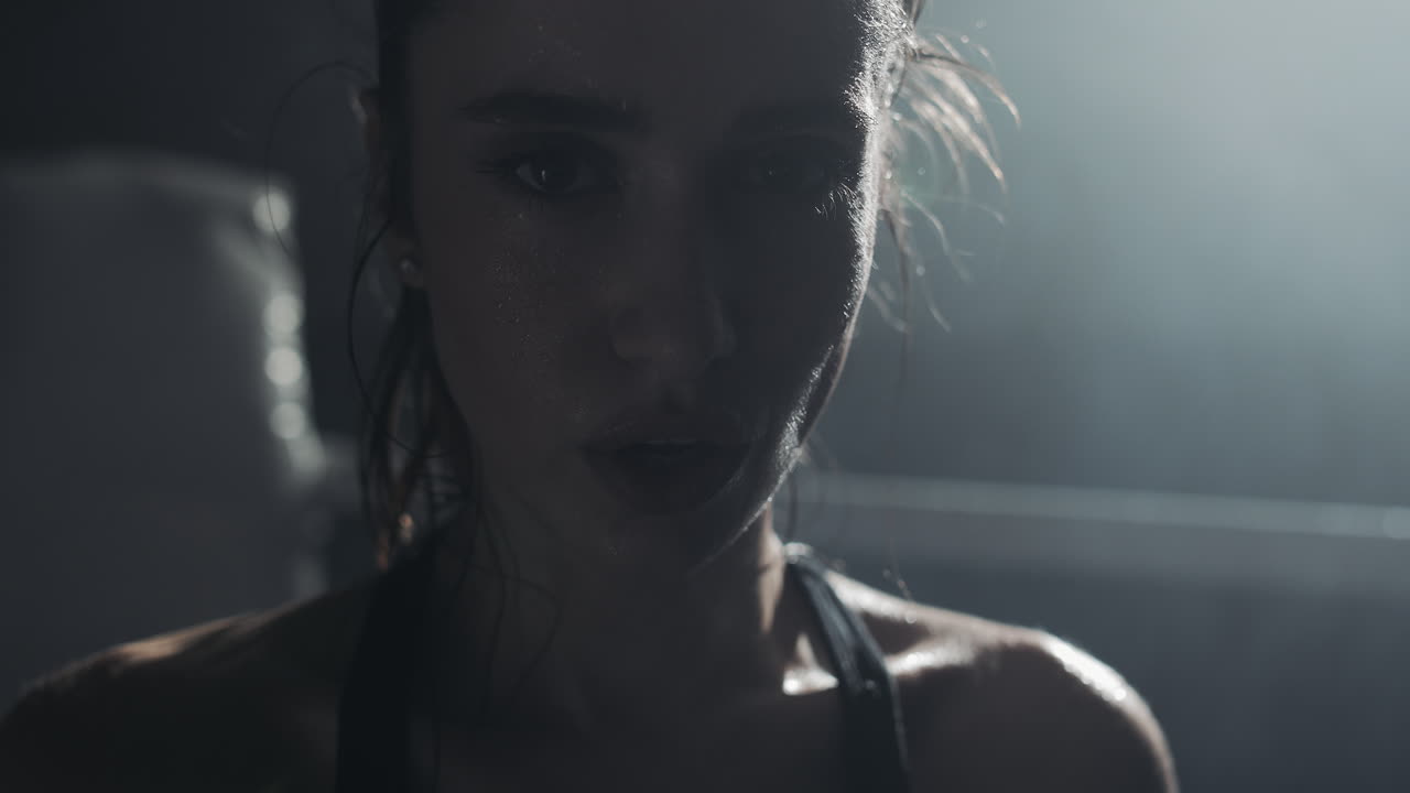 Intense close-up of a sweaty woman after a workout in a gym