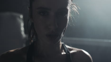 intense close-up of a sweaty woman after a workout in a gym