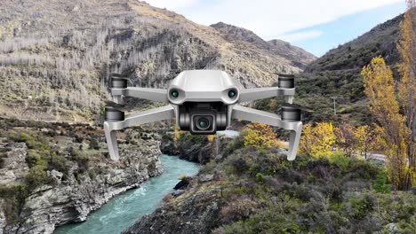 A drone navigates a picturesque canyon with a river, surrounded by rugged terrain and autumn foliage under clear skies