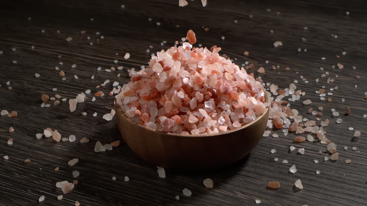 Sale rosa dell'Himalaya al rallentatore, condimento minerale naturale per cucina salutare e idee spa. Super slow motion 1500 fps