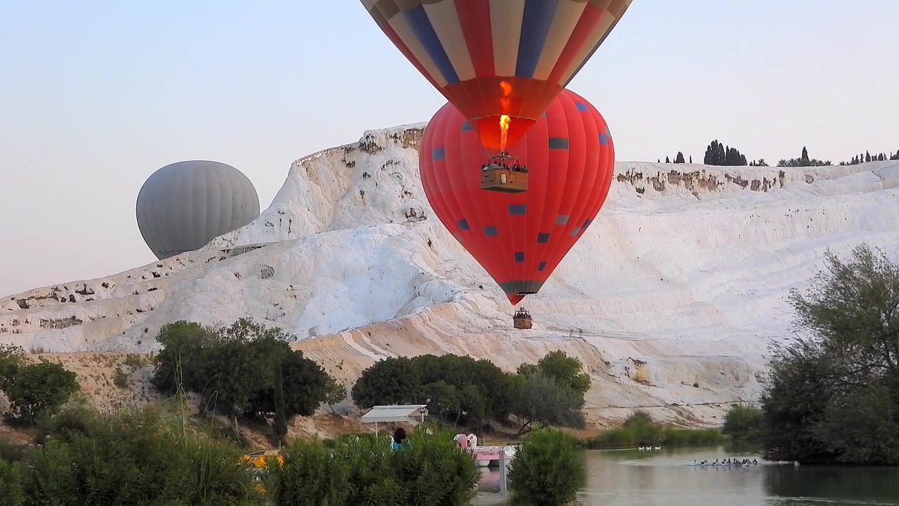 Balões de Ar Quente Voando Sobre os Travertinos de Pamukkale ao Nascer do Sol
