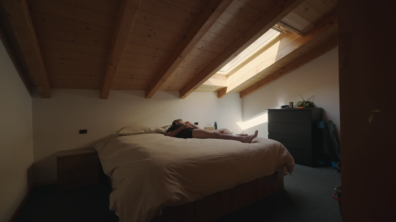 Man waking up and running out of the bedroom after watching the time on his phone