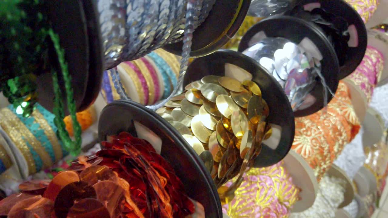 Close up of colorful sequin rolls and embroidered decorative ribbons on display