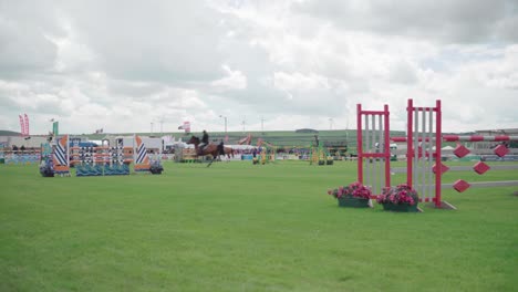 Reitwettbewerb-Auf-Einer-Landwirtschaftsausstellung---Reiter-Auf-Pferd-Springt-Hoch-Auf-Die-Hindernisstangen-In-Cornwall,-England,-Vereinigtes-Königreich