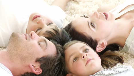 family lying on floor with heads together