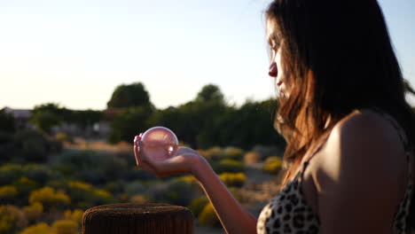 an attractive hispanic woman wizard holding a magic crystal ball casting a spell to predict the future slow motion