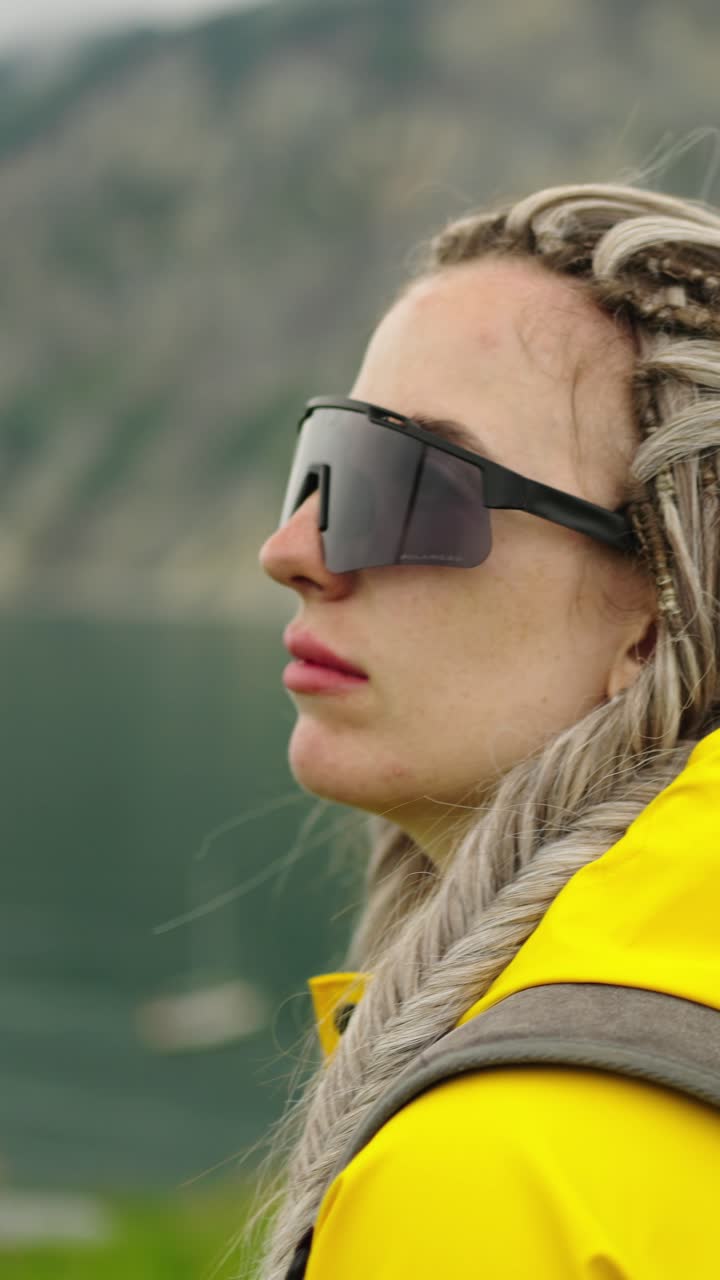 Woman in Yellow Raincoat Looking at Mountain Lake