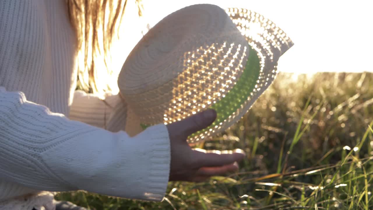 Woman using straw hat as a fan in the sunshine medium shot